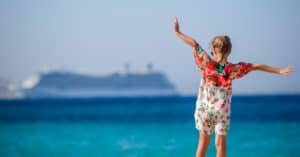 Young girl standing beside cruise ship